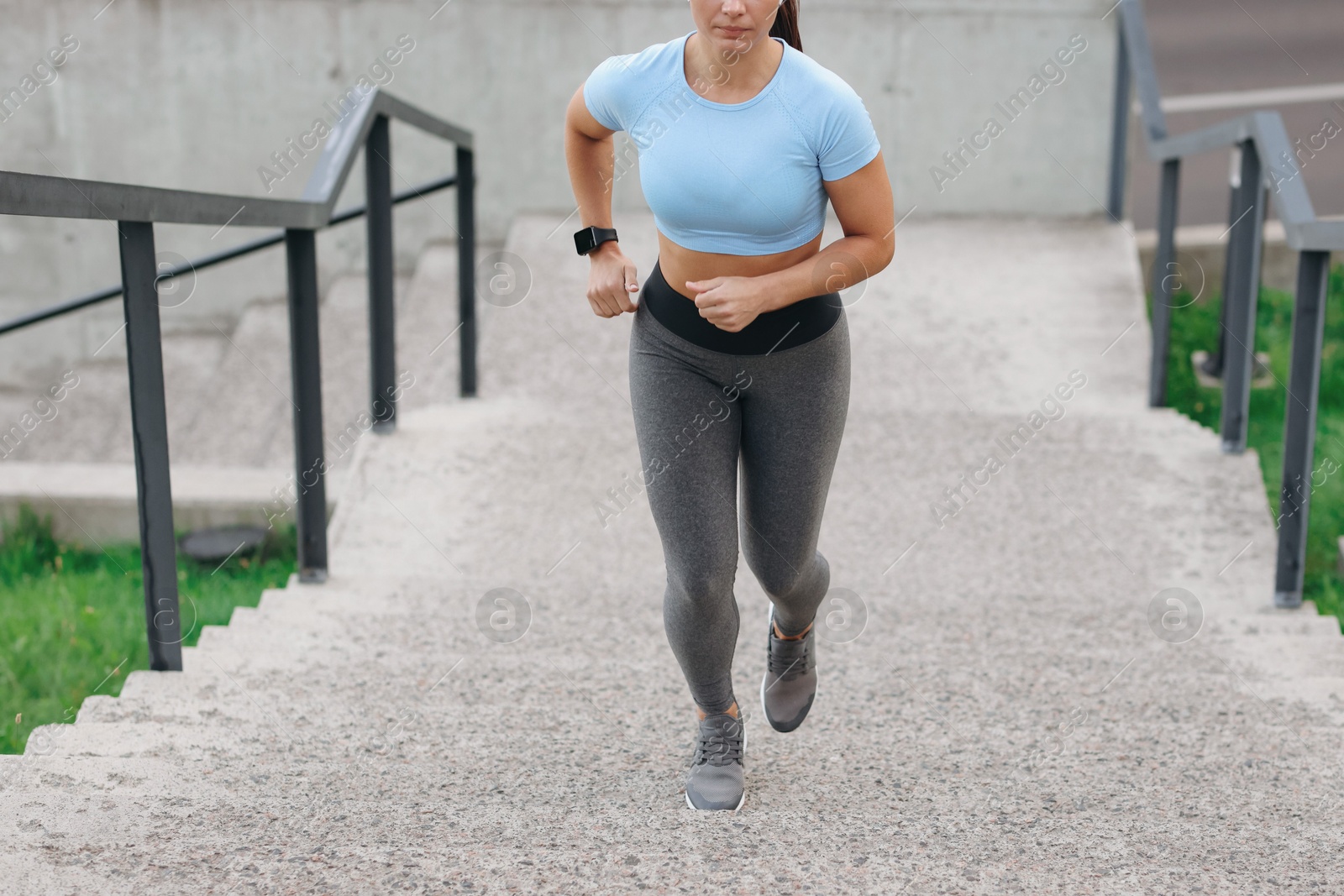 Woman in sportswear running up on stairs outdoors, closeup Photo of Woman in sportswear running up on stairs outdoors, closeup