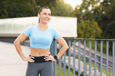 Photo of Athletic young woman in sportswear before running outdoors, space for text