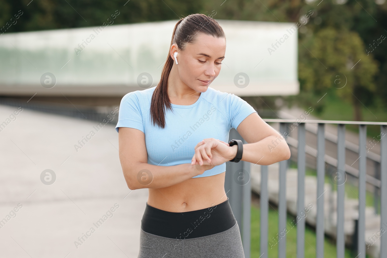 Athletic young woman checking fitness tracker before running outdoors Photo of Athletic young woman checking fitness tracker before running outdoors