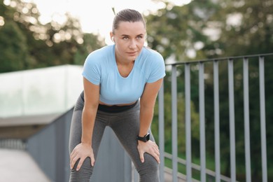 Photo of Athletic young woman in sportswear before running outdoors