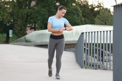 Photo of Athletic young woman in sportswear running outdoors