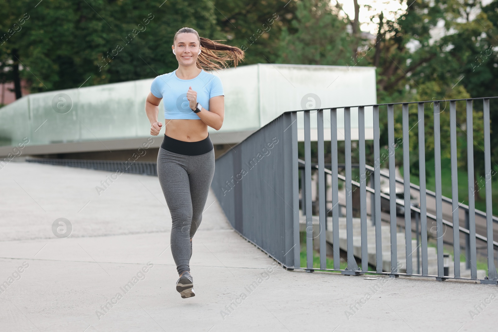 Athletic young woman in sportswear running outdoors, space for text Photo of Athletic young woman in sportswear running outdoors, space for text