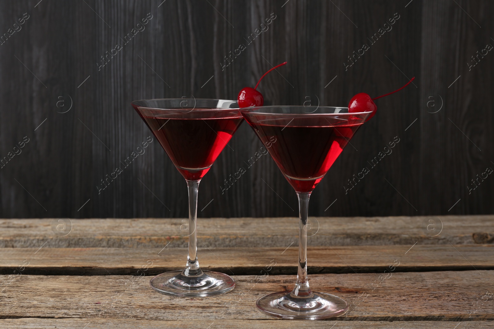 Martini cocktail with cherries in glasses on wooden table, closeup Photo of Martini cocktail with cherries in glasses on wooden table, closeup