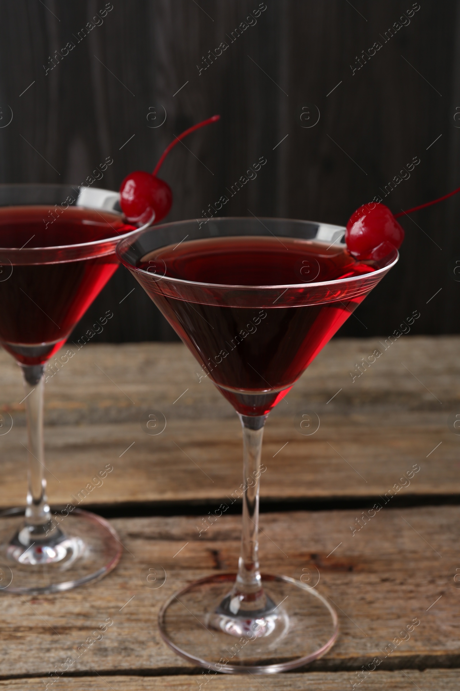 Martini cocktail with cherries in glasses on wooden table, closeup Photo of Martini cocktail with cherries in glasses on wooden table, closeup