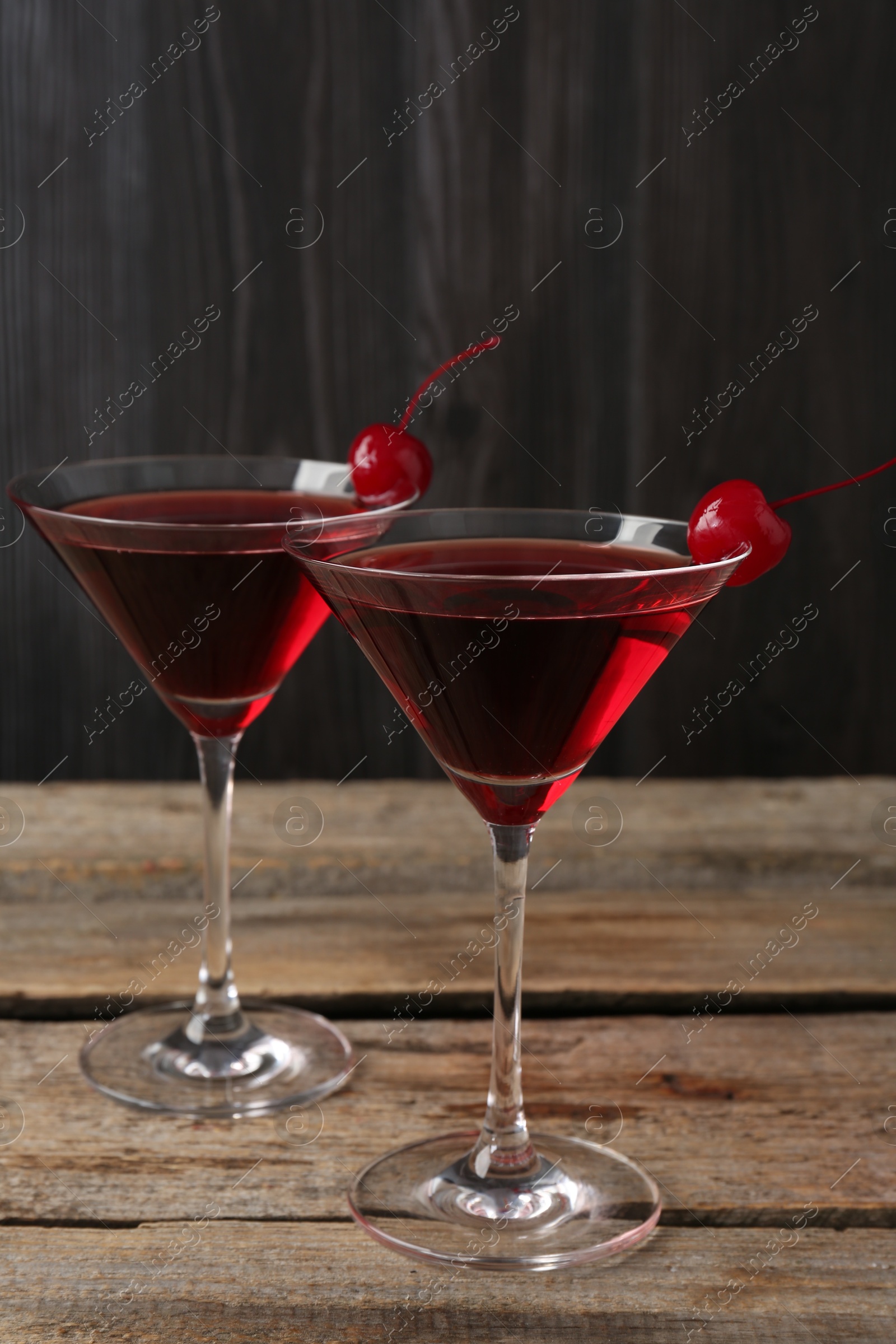 Martini cocktail with cherries in glasses on wooden table, closeup Photo of Martini cocktail with cherries in glasses on wooden table, closeup