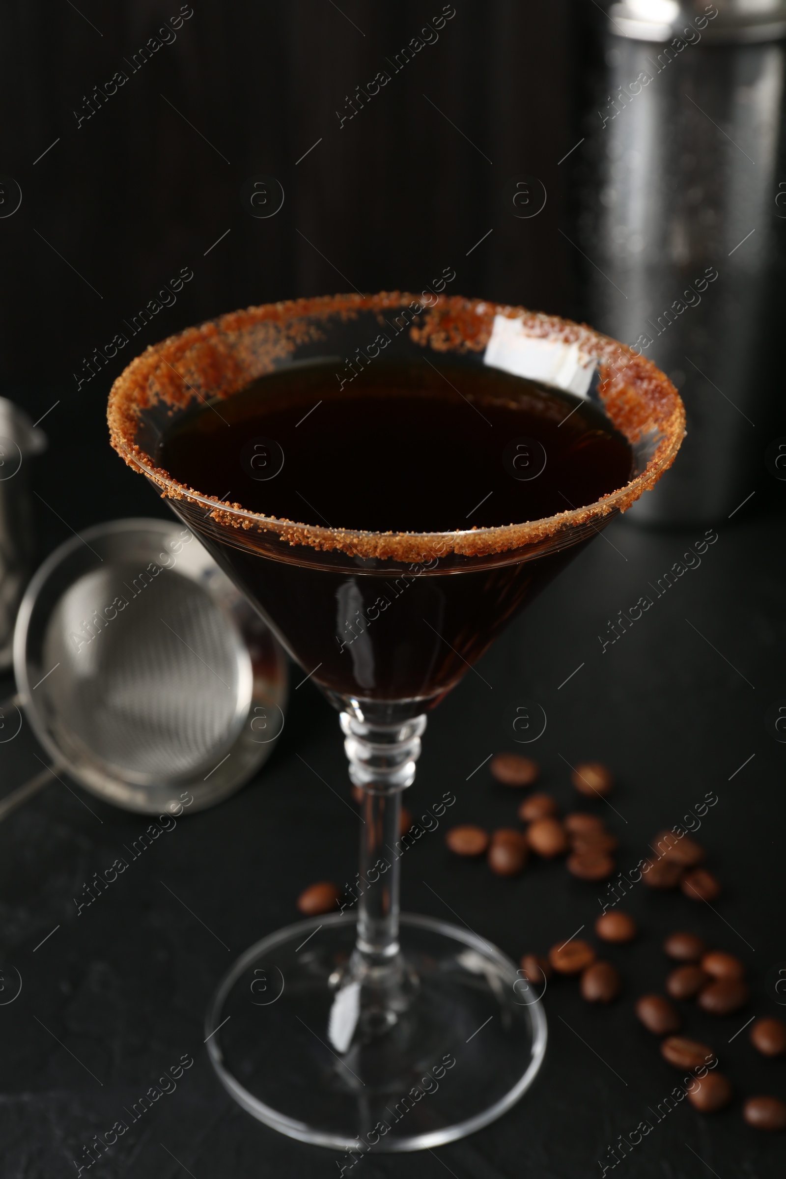 Martini cocktail with sugar in glass and coffee beans on black table, closeup Photo of Martini cocktail with sugar in glass and coffee beans on black table, closeup
