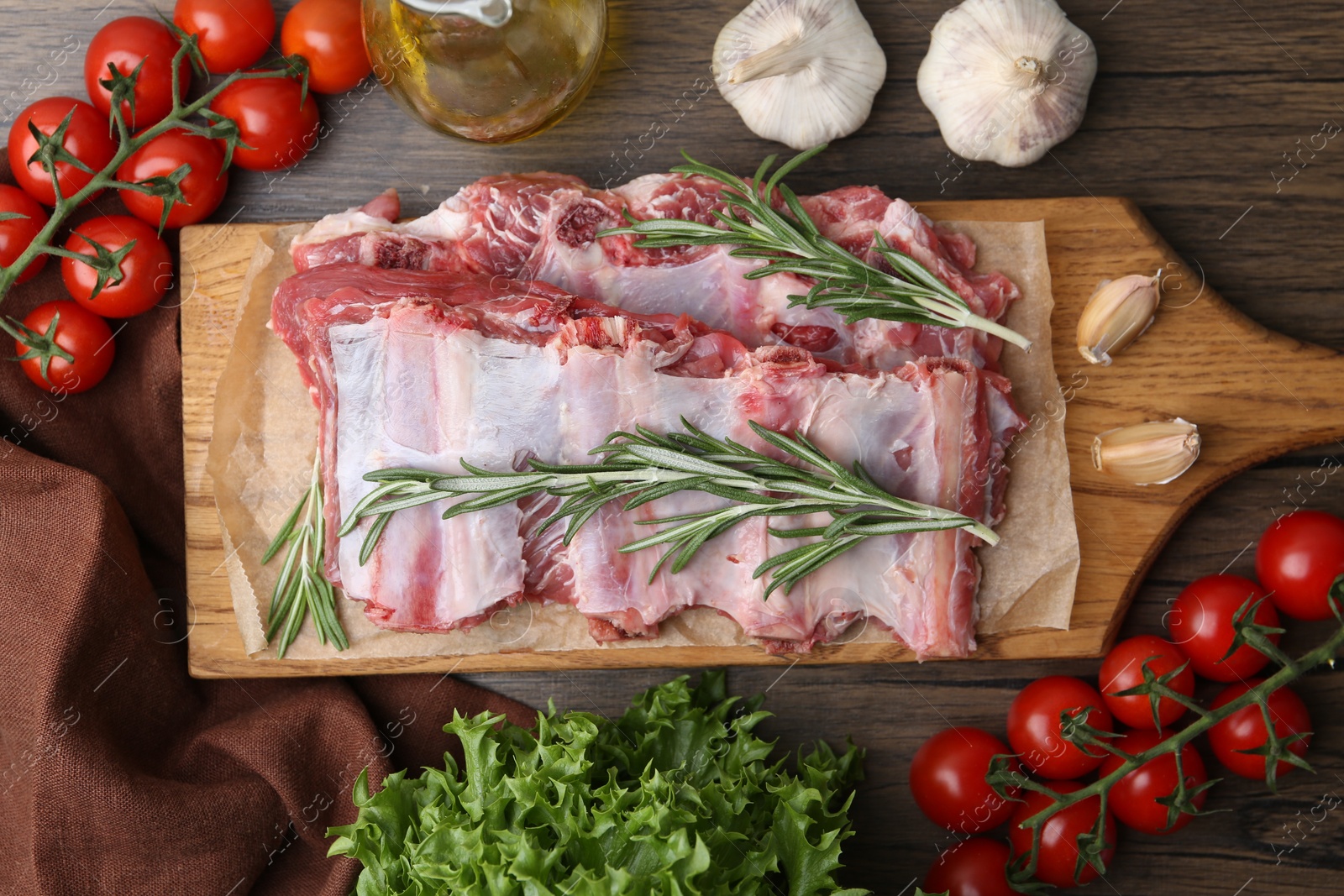 Fresh raw beef ribs and ingredients on wooden table, flat lay Photo of Fresh raw beef ribs and ingredients on wooden table, flat lay