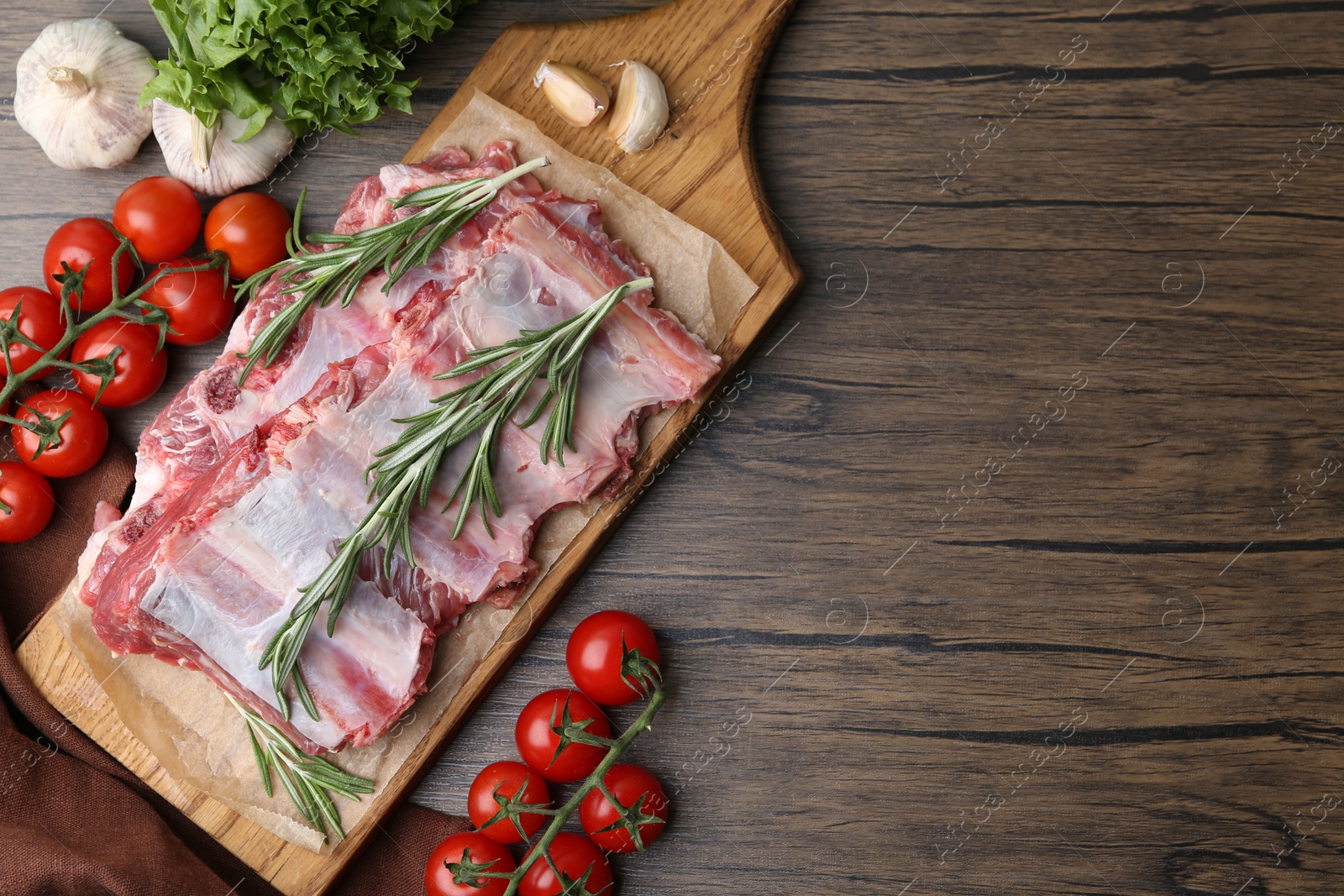 Fresh raw beef ribs and ingredients on wooden table, flat lay. Space for text Photo of Fresh raw beef ribs and ingredients on wooden table, flat lay. Space for text