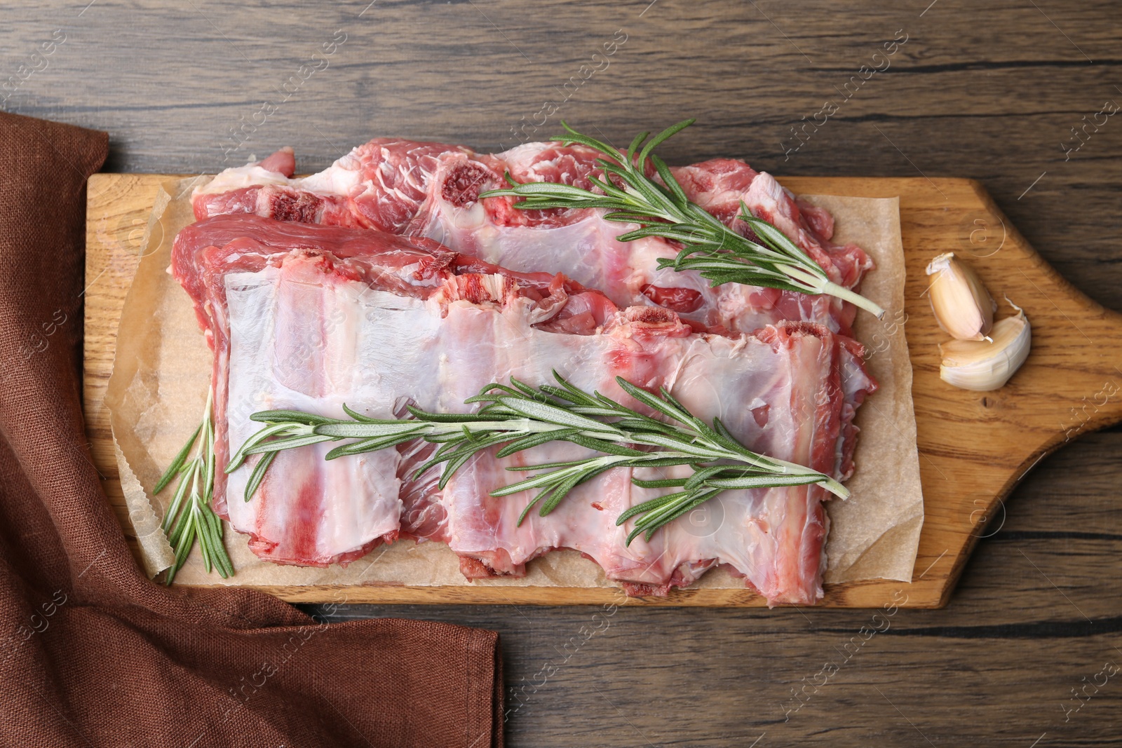 Photo of Fresh raw beef ribs and spices on wooden table, top view