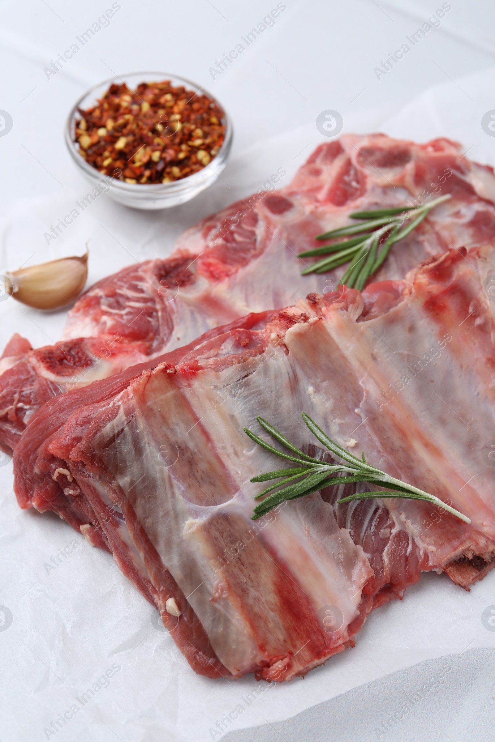 Fresh raw beef ribs and spices on white table, closeup Photo of Fresh raw beef ribs and spices on white table, closeup