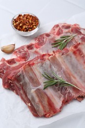 Photo of Fresh raw beef ribs and spices on white table, closeup