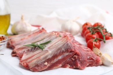 Photo of Fresh raw beef ribs, tomatoes and spices on table, closeup