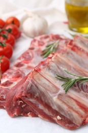 Photo of Fresh raw beef ribs, tomatoes and spices on table, closeup
