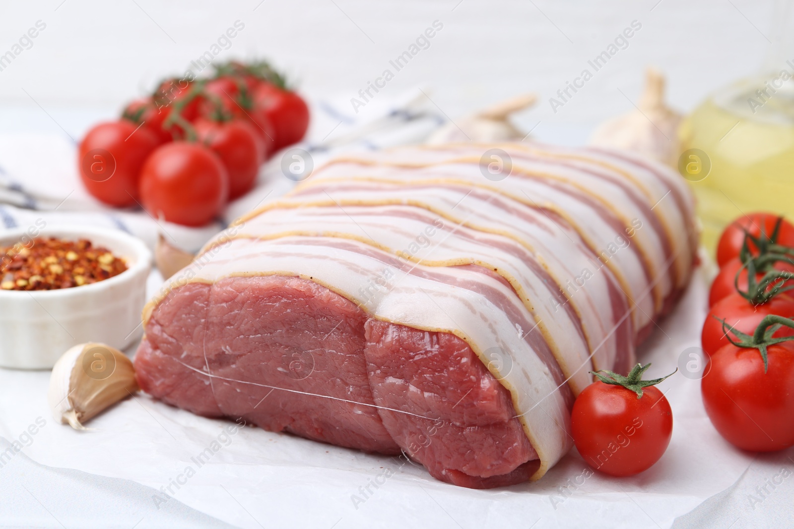 Piece of raw beef meat, tomatoes and spices on table, closeup Photo of Piece of raw beef meat, tomatoes and spices on table, closeup