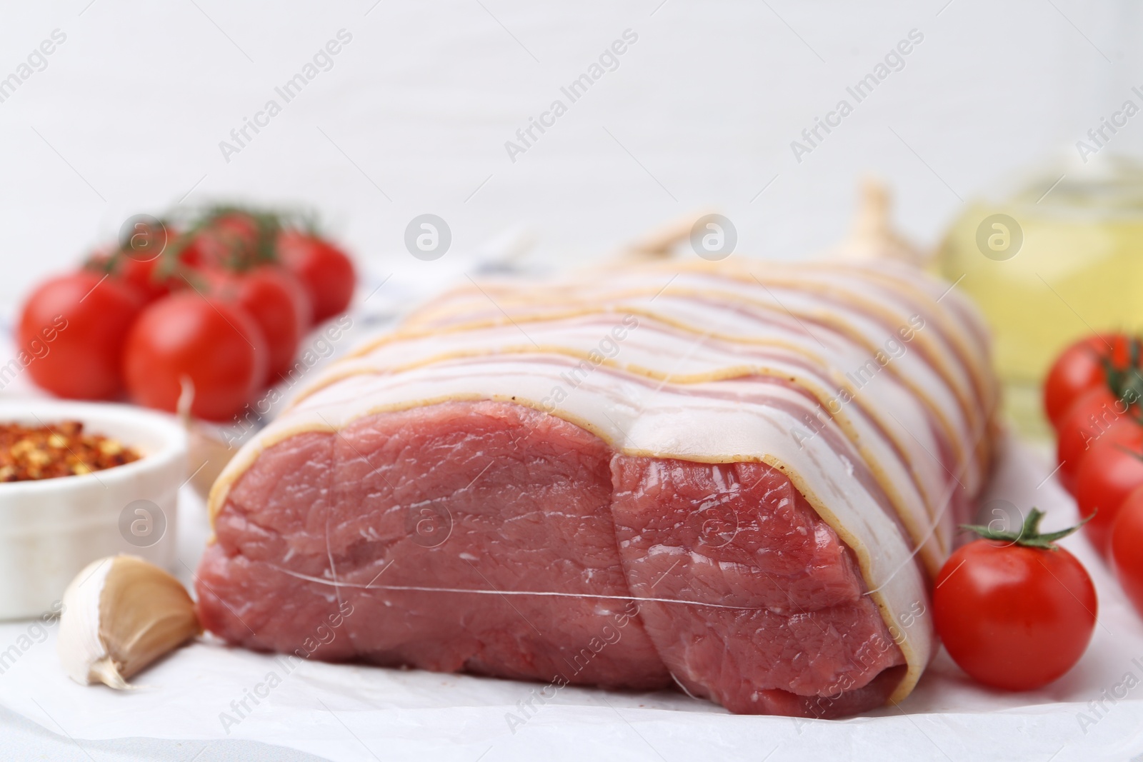 Photo of Piece of raw beef meat, tomatoes and spices on table, closeup