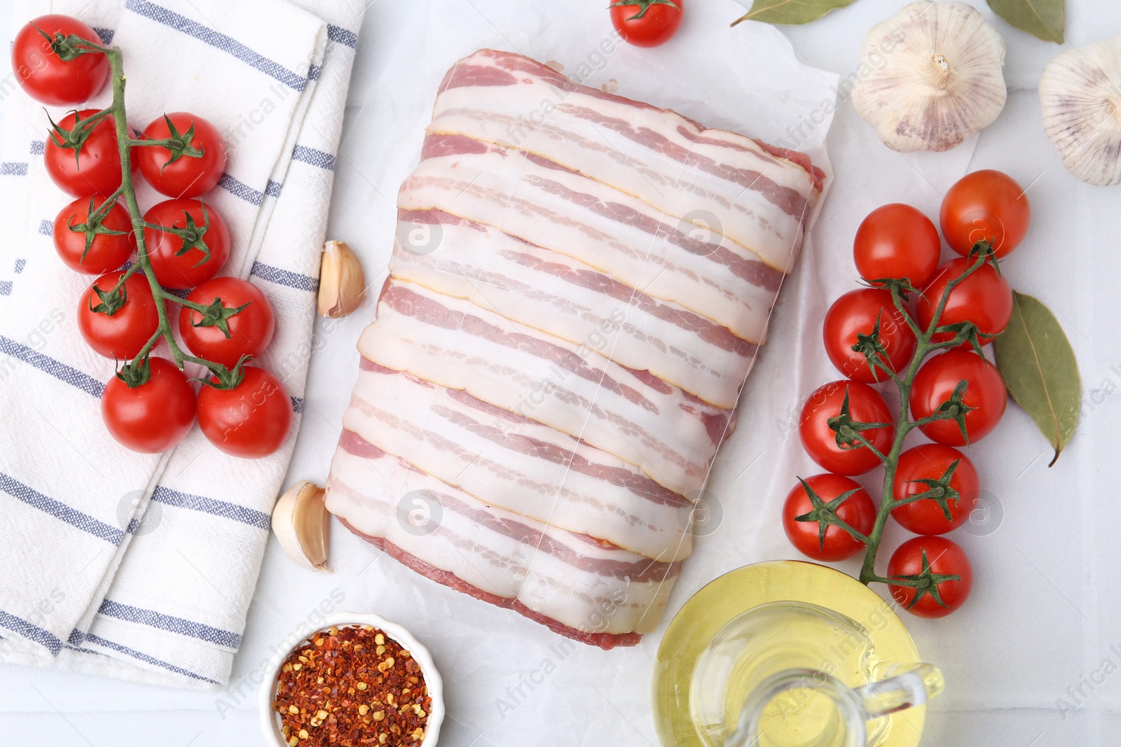 Piece of raw beef meat, tomatoes and spices on white tiled table, flat lay Photo of Piece of raw beef meat, tomatoes and spices on white tiled table, flat lay