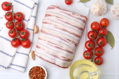 Photo of Piece of raw beef meat, tomatoes and spices on white tiled table, flat lay