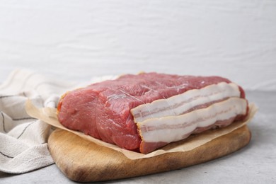 Photo of Piece of raw beef meat on grey table, closeup