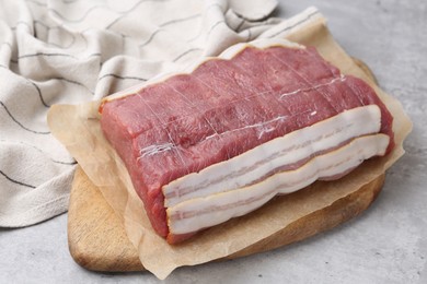 Photo of Piece of raw beef meat on grey table, closeup