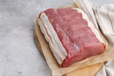 Photo of Piece of raw beef meat on grey table, closeup. Space for text