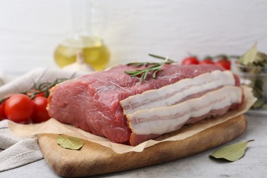 Photo of Piece of raw beef meat, tomatoes and spices on grey table, closeup
