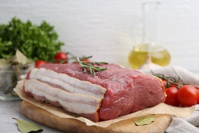 Photo of Piece of raw beef meat, tomatoes and spices on grey table, closeup