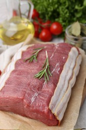 Photo of Piece of raw beef meat, tomatoes and spices on table, closeup