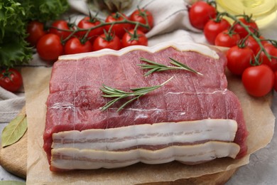 Photo of Piece of raw beef meat, tomatoes and spices on table, closeup