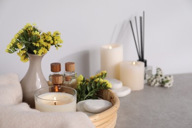 Photo of Spa composition with burning candles on light grey table, closeup