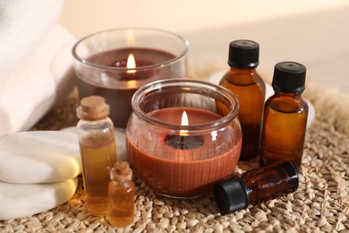 Photo of Spa composition with burning candles on table against beige background, closeup
