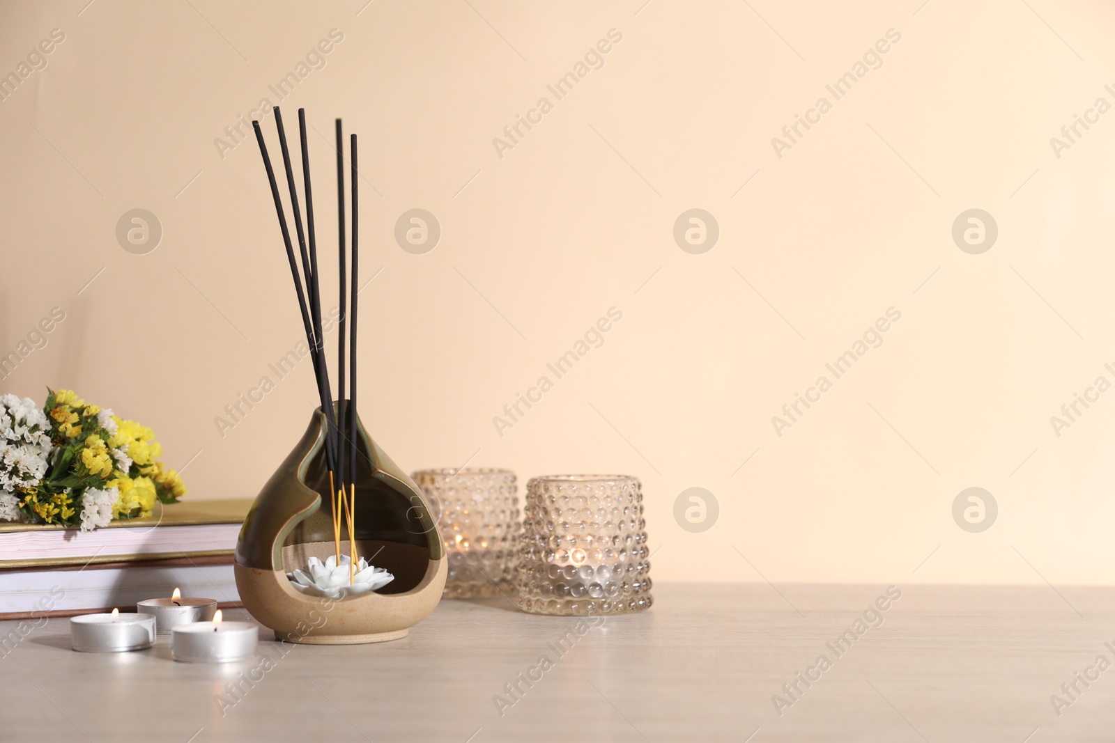 Spa composition with burning candles on wooden table against beige background, space for text Photo of Spa composition with burning candles on wooden table against beige background, space for text
