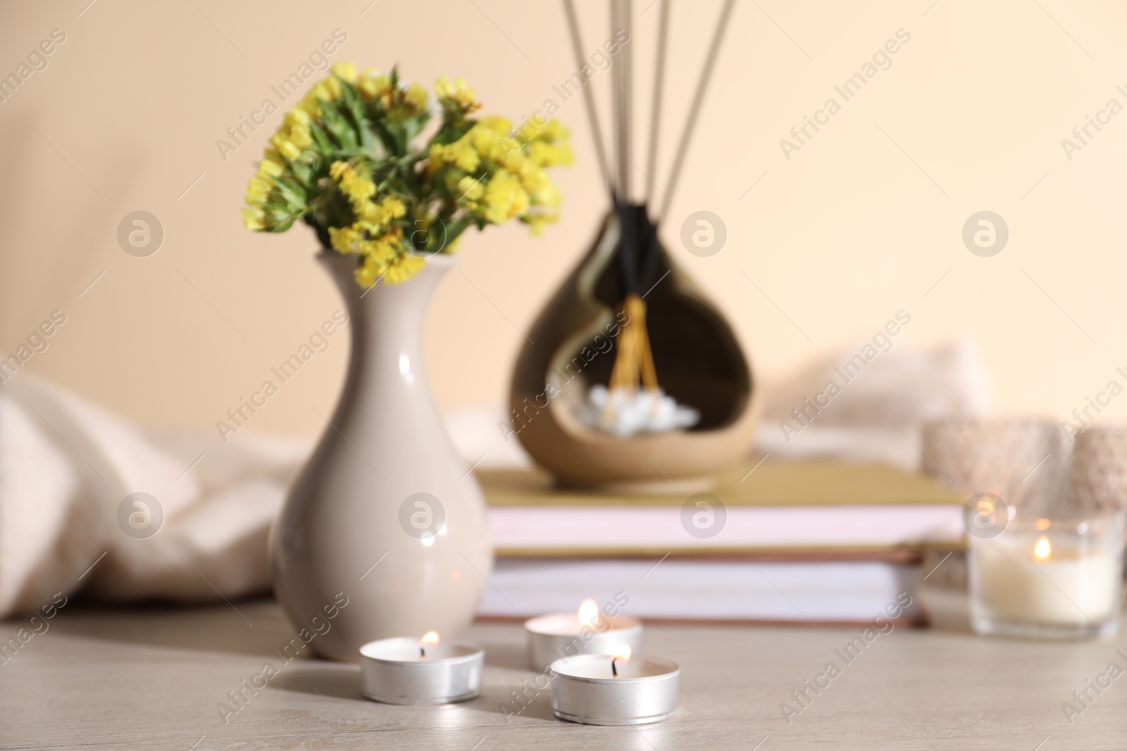Spa composition with burning candles on wooden table against beige background, closeup Photo of Spa composition with burning candles on wooden table against beige background, closeup