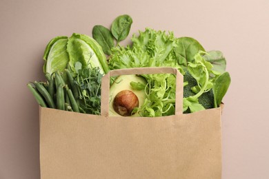 Photo of Superfood. Different healthy products in paper bag on beige background, top view
