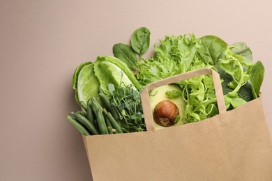 Photo of Superfood. Different healthy products in paper bag on beige background, top view