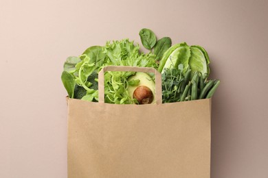 Photo of Superfood. Different healthy products in paper bag on beige background, top view