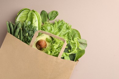 Photo of Superfood. Different healthy products in paper bag on beige background, top view. Space for text