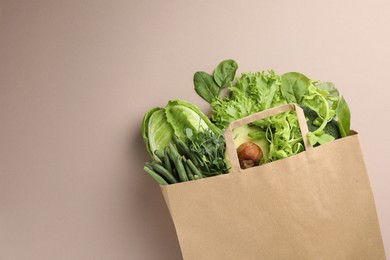 Photo of Superfood. Different healthy products in paper bag on beige background, top view. Space for text