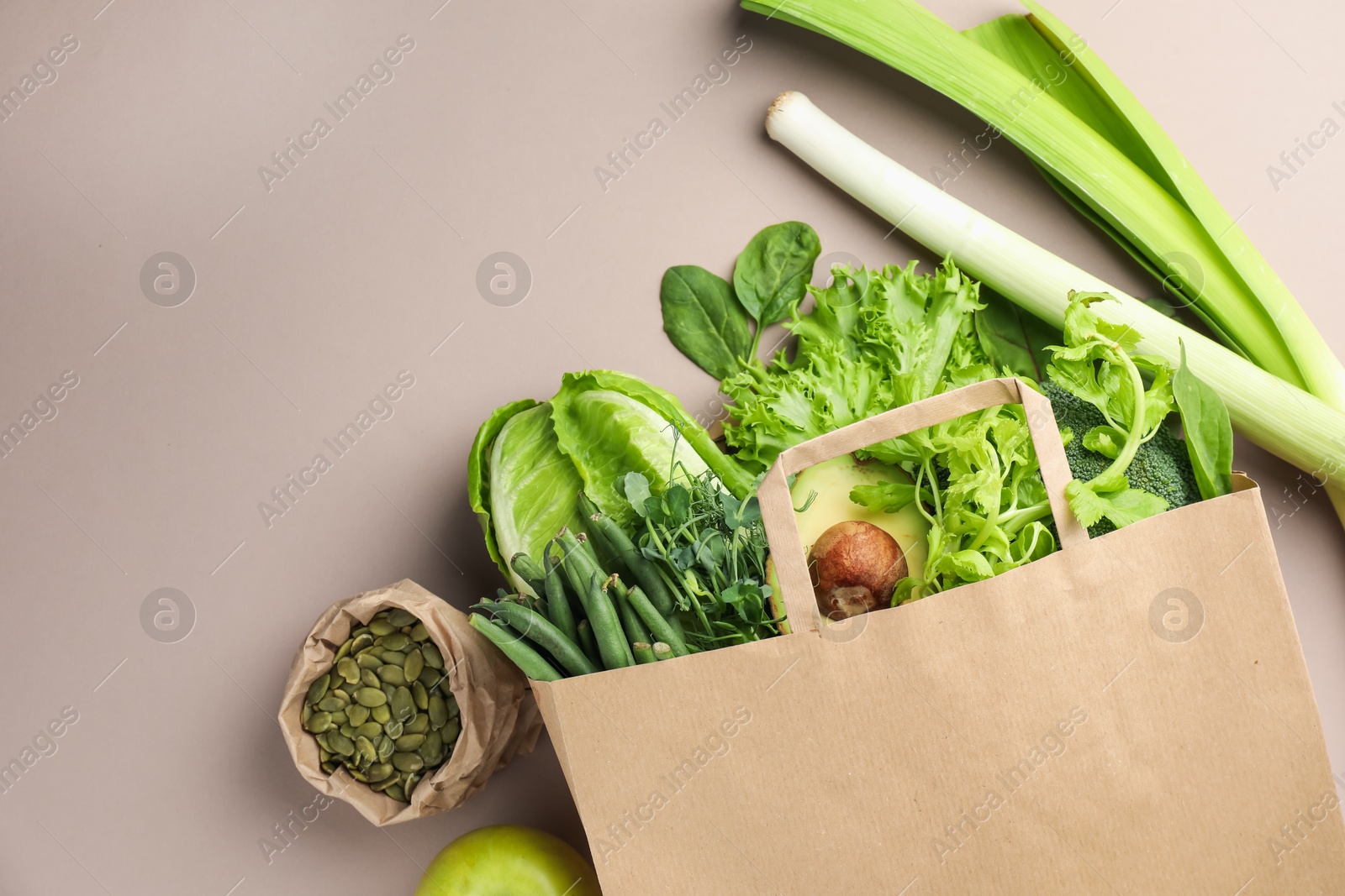 Photo of Superfood. Different healthy products in paper bag on beige background, top view. Space for text