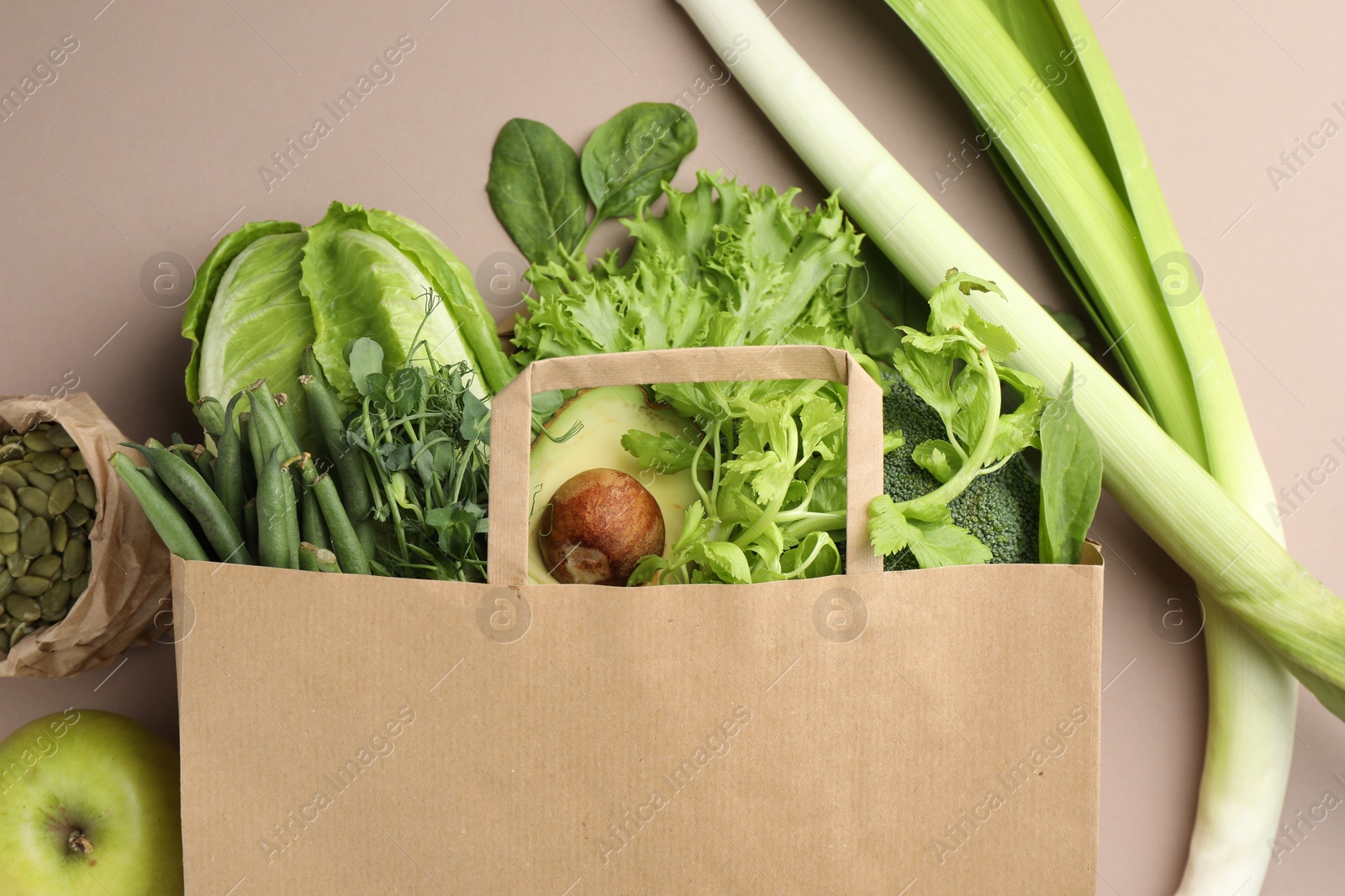 Superfood. Different healthy products in paper bag on beige background, top view Photo of Superfood. Different healthy products in paper bag on beige background, top view