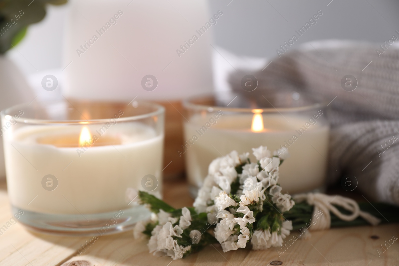 Burning candles and flowers on wooden table, closeup Photo of Burning candles and flowers on wooden table, closeup