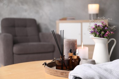 Photo of Spa composition with burning candles on wooden table indoors, closeup. Space for text