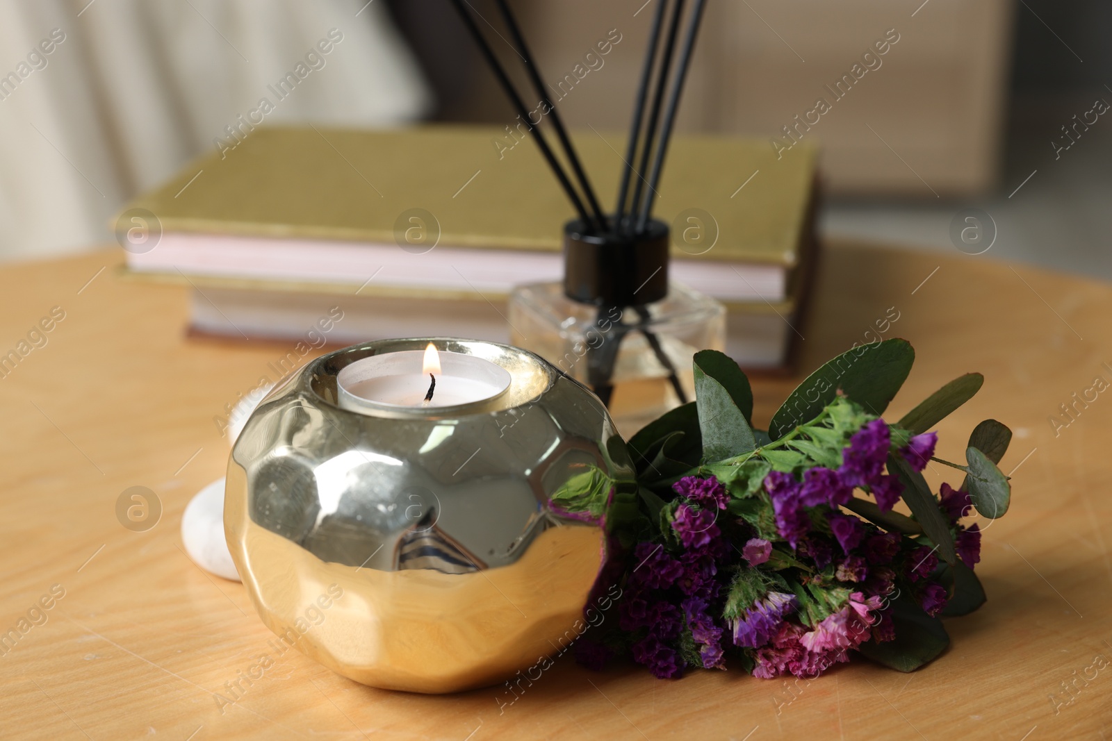 Spa composition with burning candle and reed diffuser on wooden table indoors, closeup Photo of Spa composition with burning candle and reed diffuser on wooden table indoors, closeup