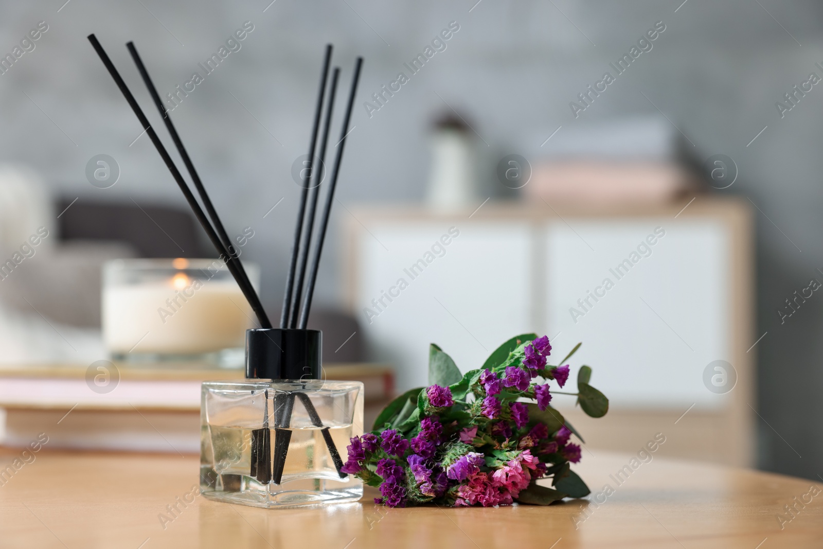 Reed diffuser and aromatic flowers on wooden table, closeup Photo of Reed diffuser and aromatic flowers on wooden table, closeup