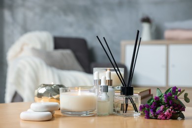 Photo of Spa composition with burning candles on wooden table indoors, closeup