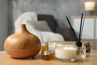 Photo of Spa composition with burning candles on wooden table indoors, closeup