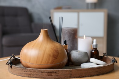 Photo of Spa composition with burning candles on wooden table indoors, closeup