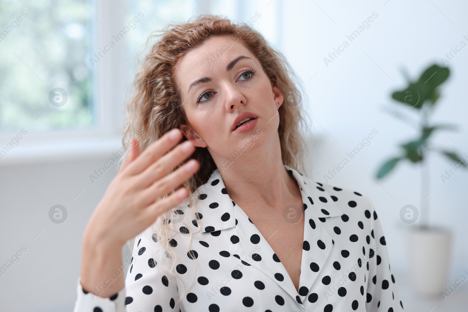 Air conditioning. Woman suffering from heat at workplace in office Photo of Air conditioning. Woman suffering from heat at workplace in office