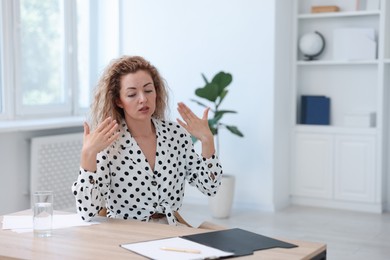 Photo of Air conditioning. Woman suffering from heat at workplace in office