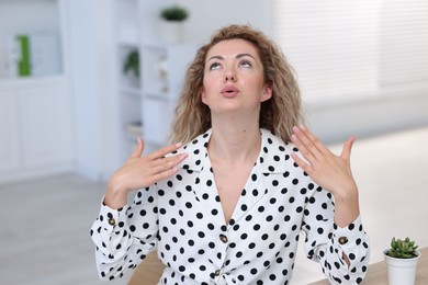Photo of Air conditioning. Woman suffering from heat at workplace in office