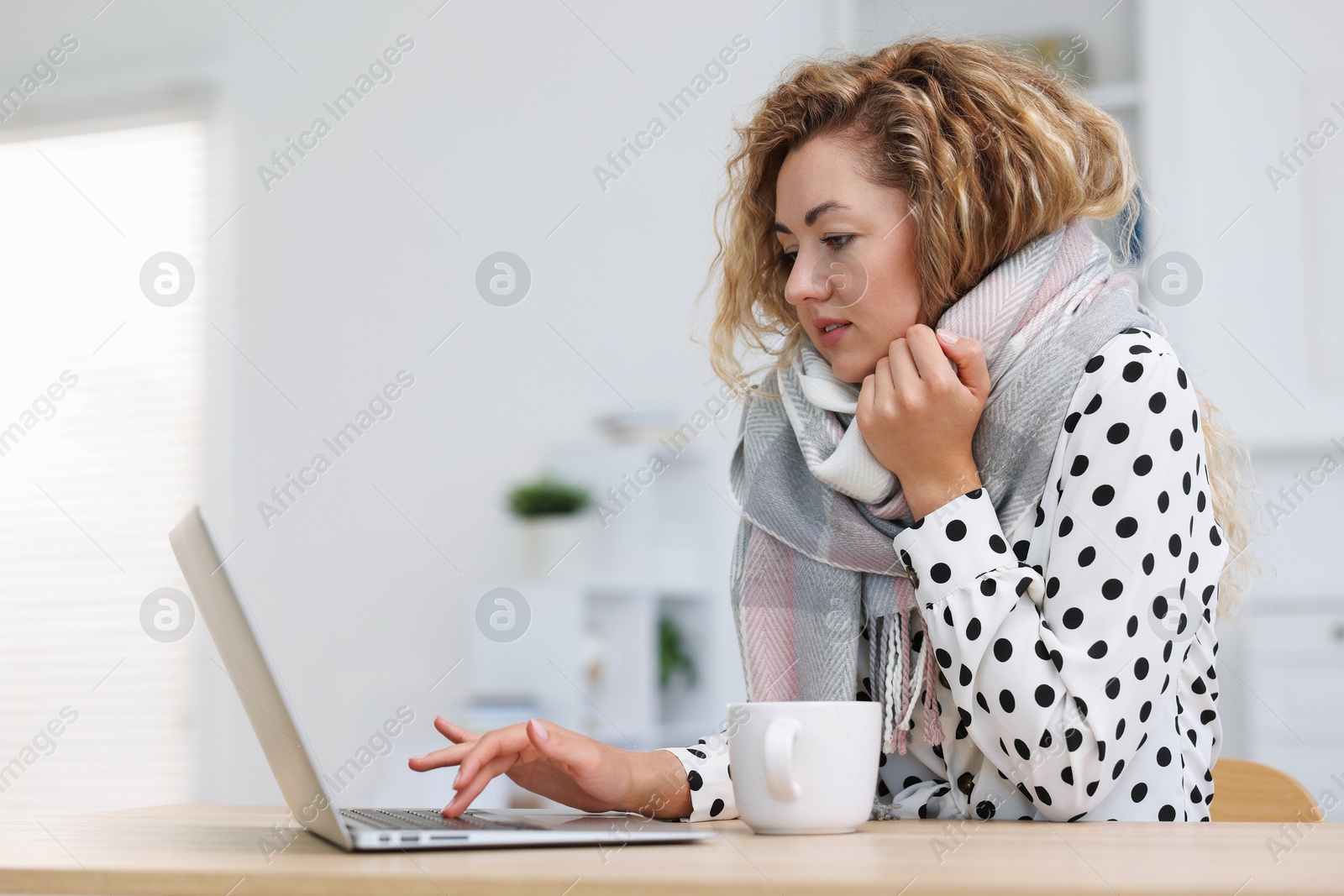 Air conditioning. Woman with scarf suffering from cold temperature at workplace in office Photo of Air conditioning. Woman with scarf suffering from cold temperature at workplace in office